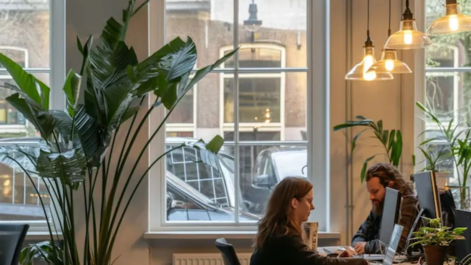 Zwei Personen arbeiten an Schreibtischen in einem hellen Büro
