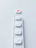 Reihe weisser 3D-Hakenknoepfe, ein roter Haken oben abgesetzt.