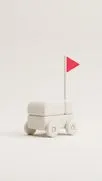 Minimalistischer weißer Spielzeugwagen auf Rädern mit einer kleinen roten dreieckigen Flagge