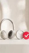 Weißes Headset mit Mikrofon neben einer weißen Uhr und einem roten Häkchen-Abzeichen auf Beige.